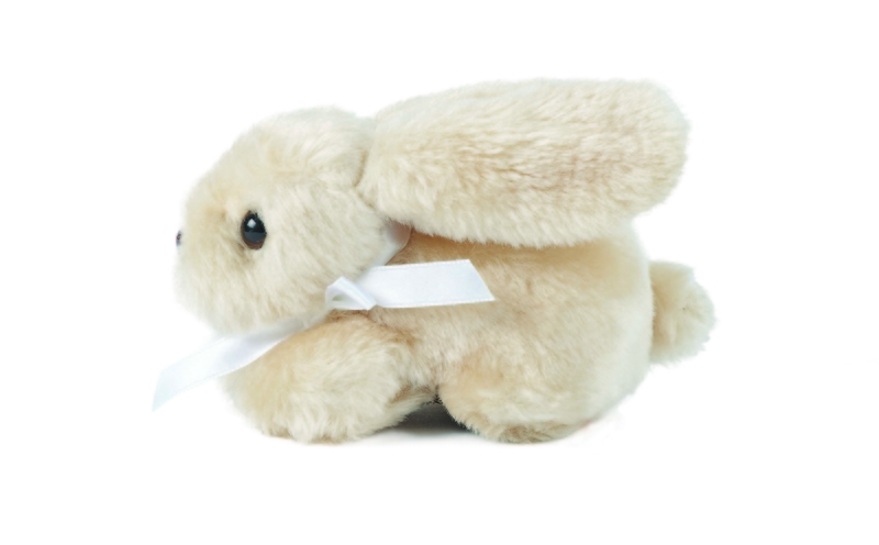 Beige fluffig liten kanin med vit rosett